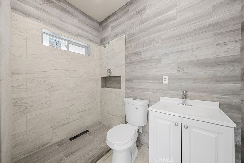 26251 Ravenhill Road Canyon Country, CA 91387 - Photo 35 of 64 a white toilet sitting next to a bathroom sink