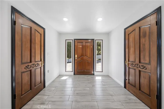 a view of a hallway with wooden floor and windows