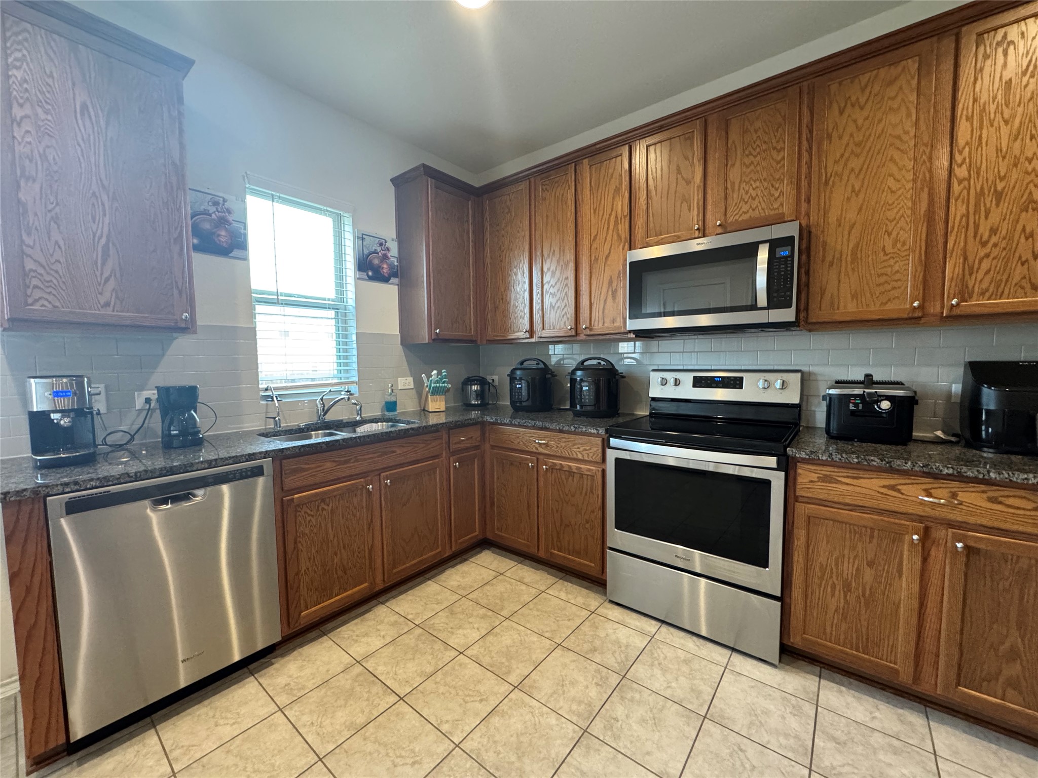13017 Foreston Drive Austin, TX 78754 - Photo 6 of 12 a kitchen with stainless steel appliances granite countertop a stove sink microwave and window