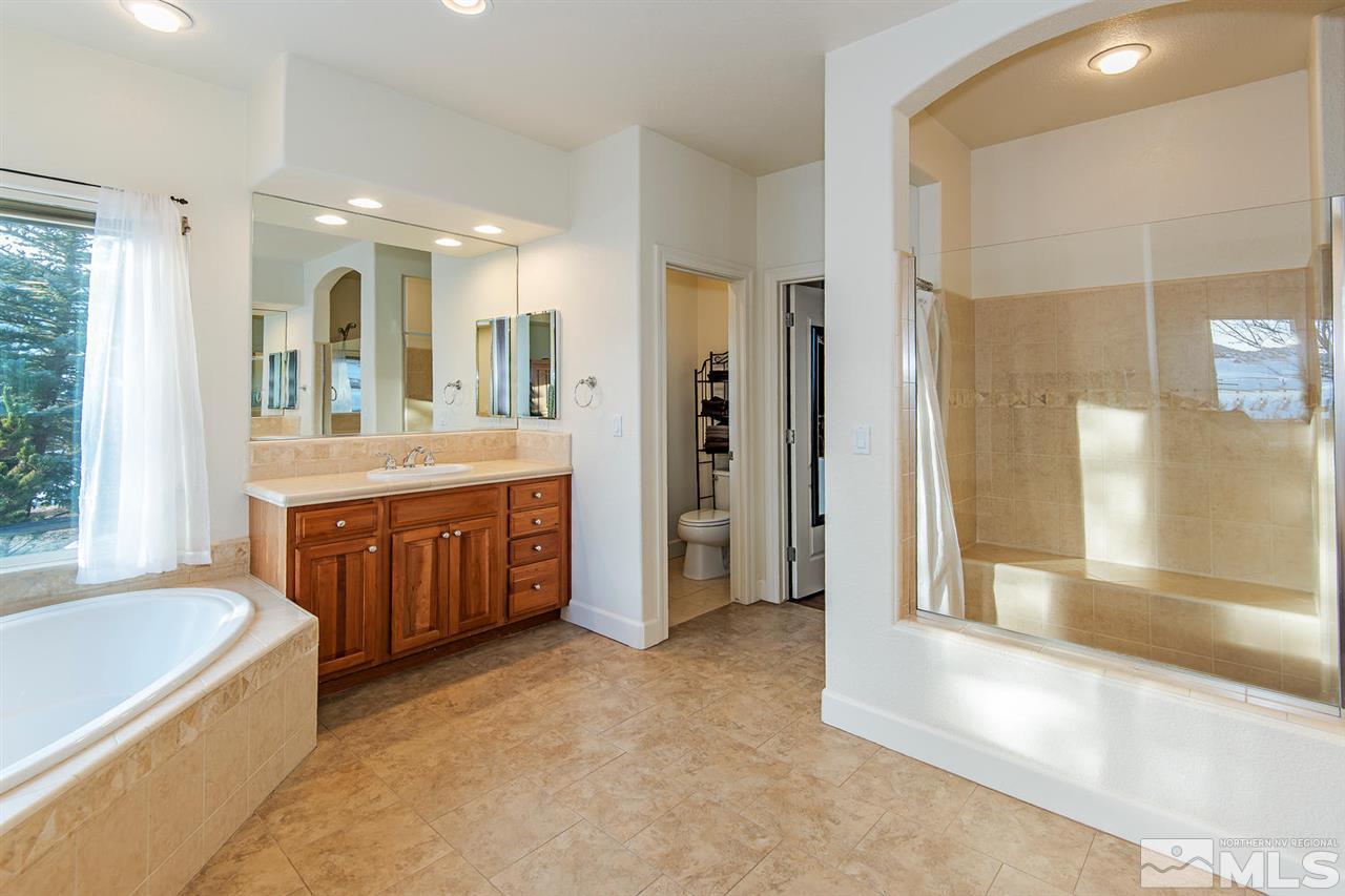 6965 Cour Street Reno, NV 89511 - Photo 12 of 25 a bathroom with a tub a sink and a large mirror