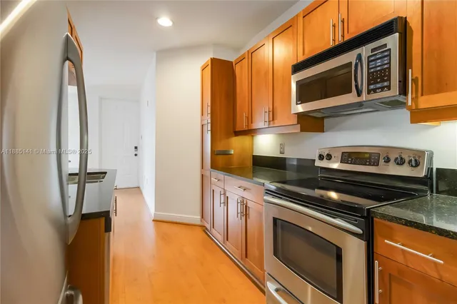 a kitchen with stainless steel appliances granite countertop a refrigerator and a stove