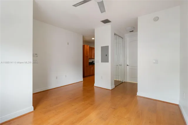 a view of empty room with wooden floor