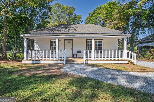 a view of a house with a backyard and a tree