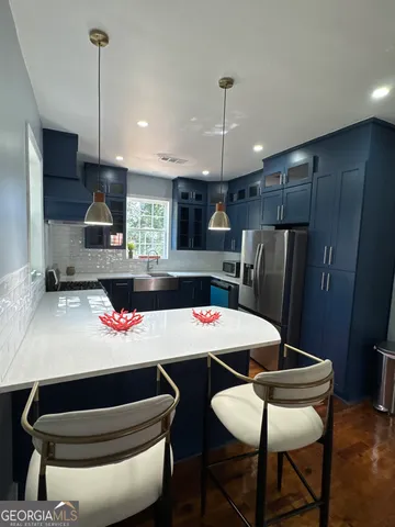 a kitchen with a table chairs refrigerator and microwave