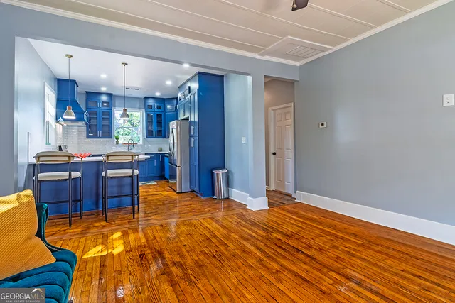 a view of kitchen with stainless steel appliances kitchen island granite countertop a refrigerator and a stove top oven