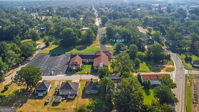 an aerial view of house with yard swimming pool and large trees