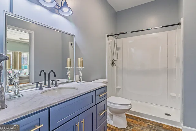 a bathroom with a granite countertop sink toilet and shower