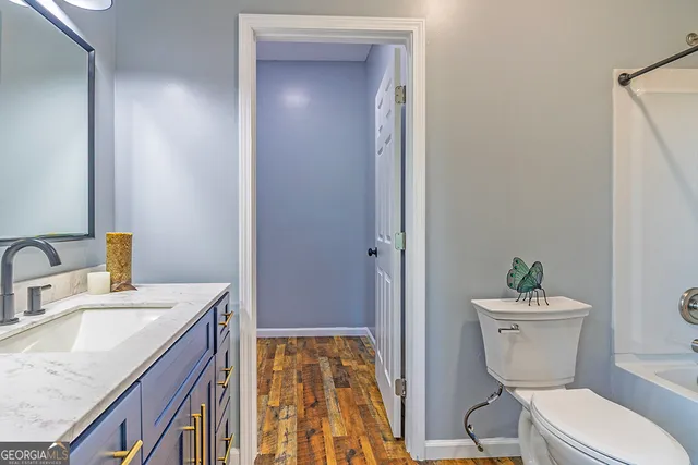 a bathroom with a granite countertop sink toilet and shower