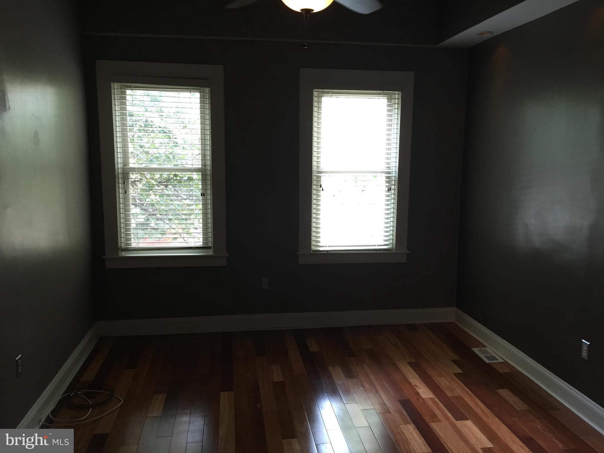 3131 Elliott Street Baltimore, MD 21224 - Photo 8 of 14 a view of an empty room with wooden floor and a window