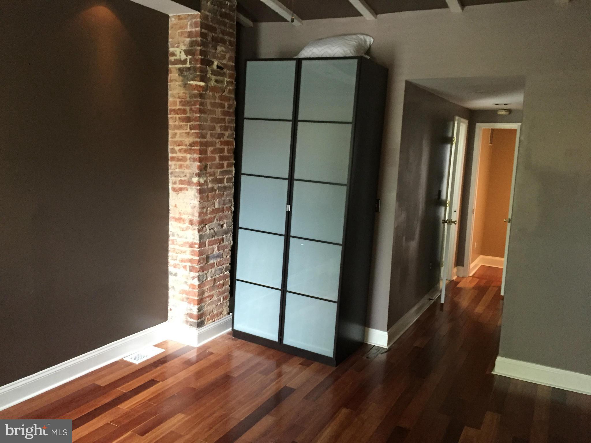 3131 Elliott Street Baltimore, MD 21224 - Photo 9 of 14 an empty room with wooden floor and windows