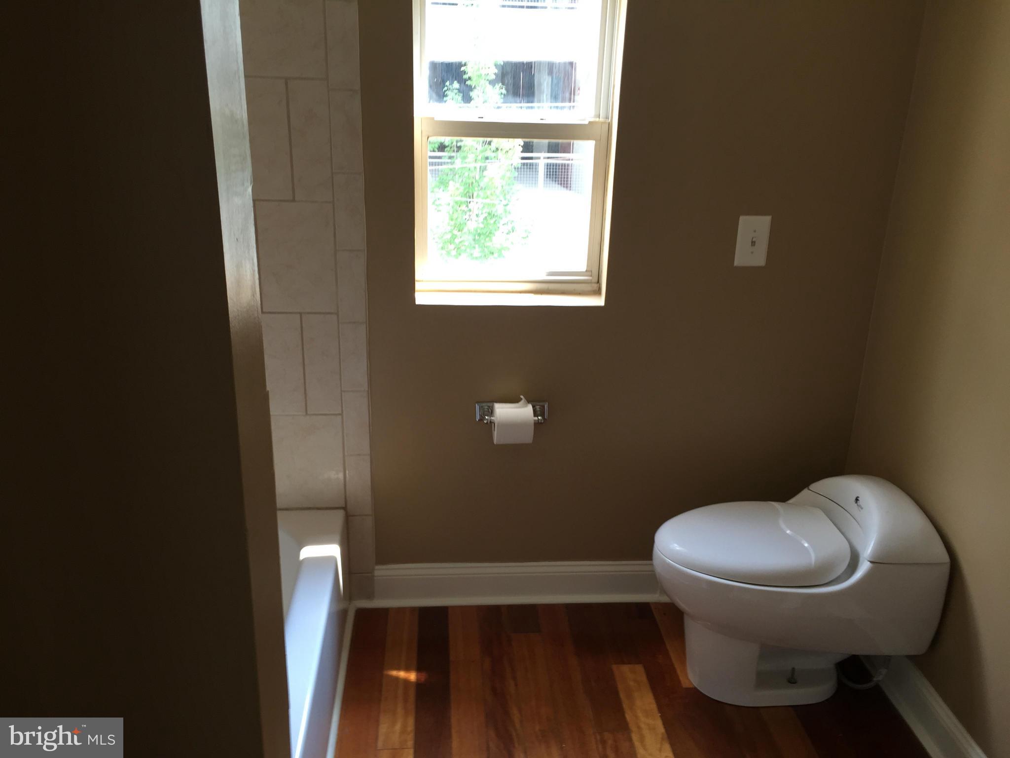 3131 Elliott Street Baltimore, MD 21224 - Photo 10 of 14 a white toilet sitting next to a window