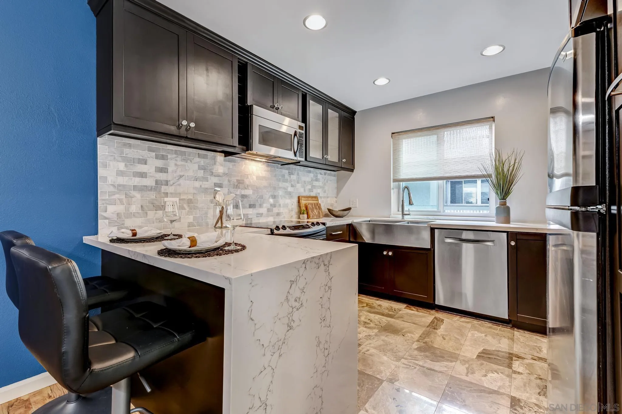 5370 La Jolla Boulevard, Unit 201B La Jolla, CA 92037 - Photo 5 of 31 a kitchen with a stove a sink a microwave a dining table and chairs