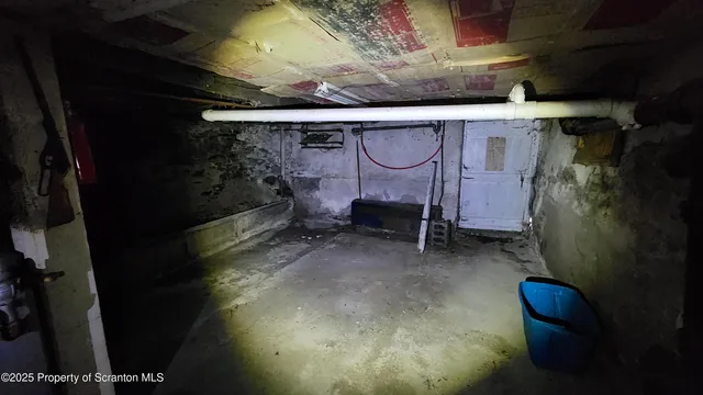 a room with water heater and wooden cabinets