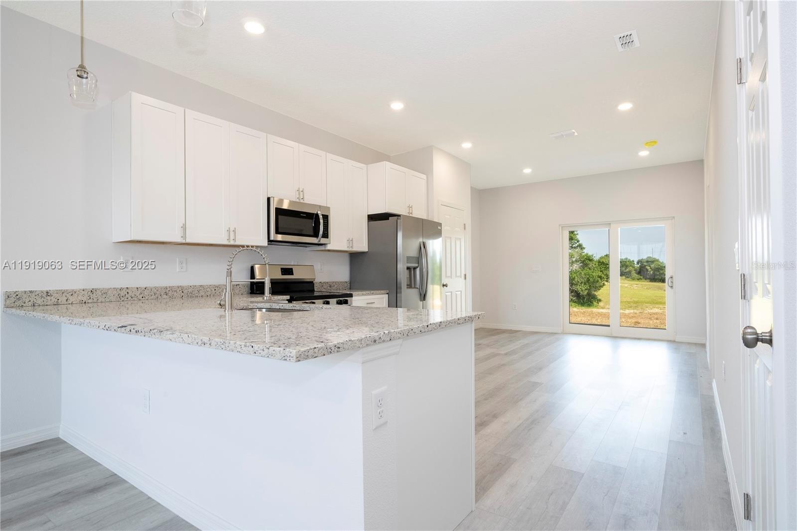 833 Colville Drive, Unit 833 Kissimmee, FL 34759 - Photo 12 of 47 a kitchen with granite countertop a stove a sink and a microwave