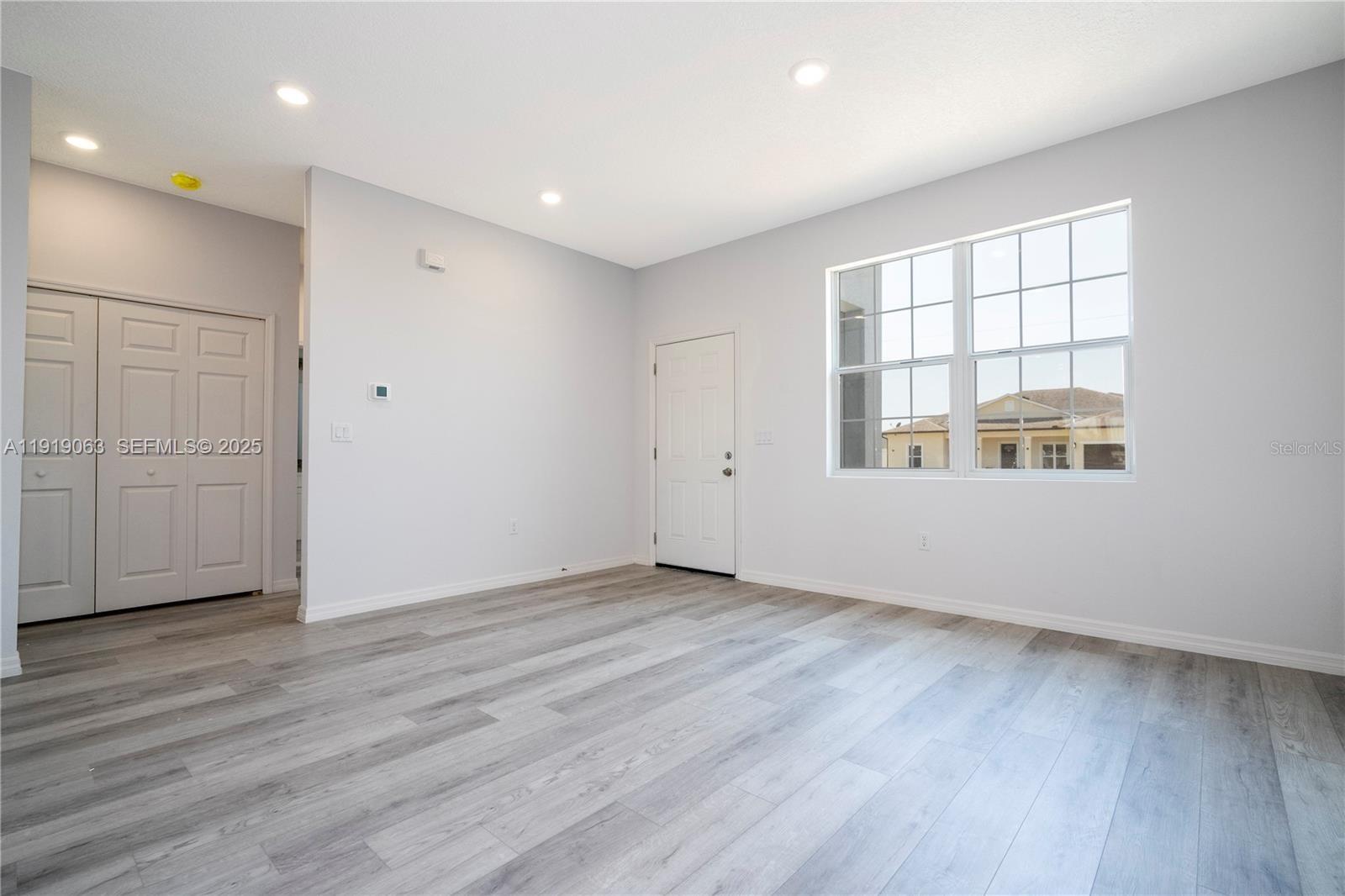 833 Colville Drive, Unit 833 Kissimmee, FL 34759 - Photo 10 of 47 an empty room with wooden floor and windows