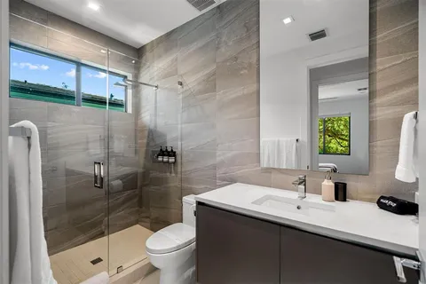 a bathroom with a sink a toilet and shower