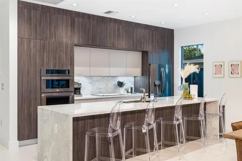 a kitchen with kitchen island granite countertop a stove top oven a sink and dishwasher