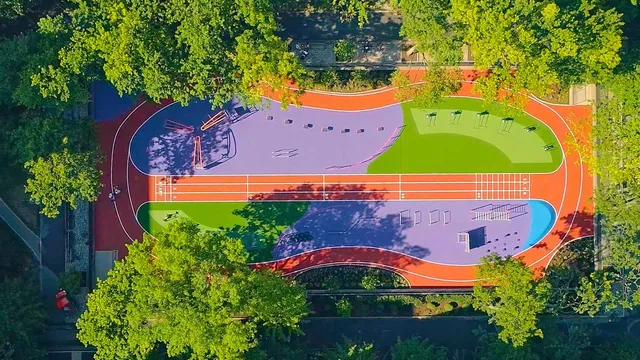 an aerial view of a tennis ground and trees in the background