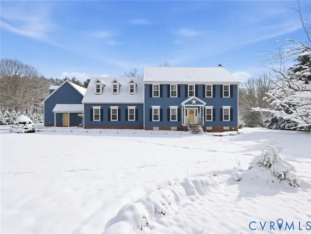 a front view of a house with a yard covered with snow