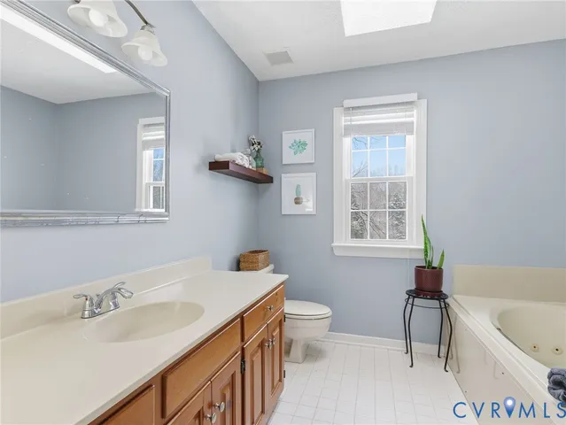 a bathroom with a granite countertop sink a toilet and bathtub