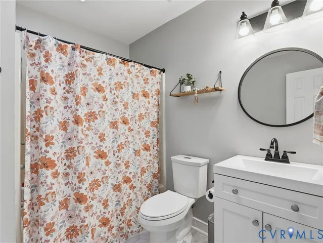 a bathroom with a toilet sink vanity and mirror