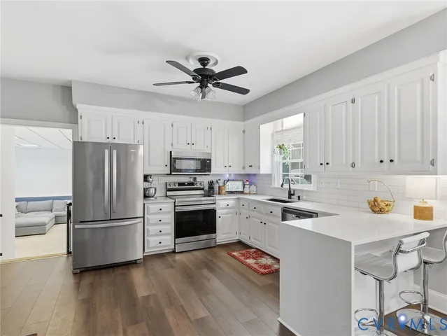 a kitchen with a refrigerator a stove top oven a sink and cabinets