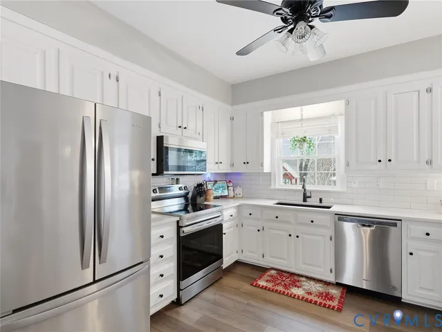 a kitchen with white cabinets and white appliances
