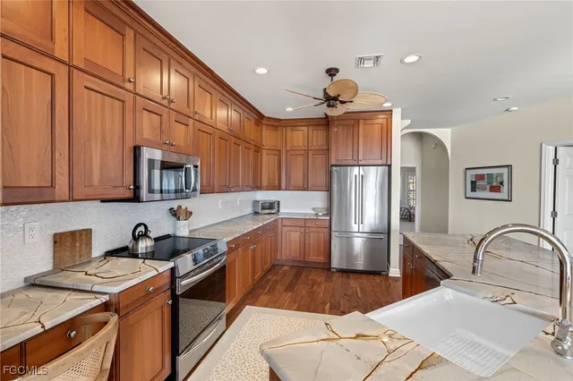 a kitchen with stainless steel appliances granite countertop a sink a stove and refrigerator