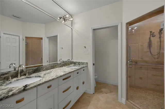 a bathroom with a granite countertop sink mirror and a shower