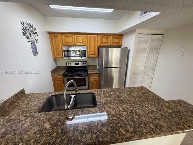 a kitchen with kitchen island a counter top space cabinets and a refrigerator