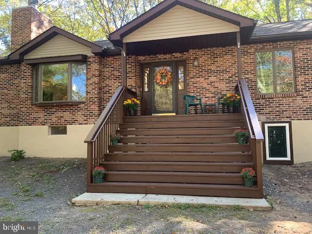 a view of a house with stairs and wooden fence