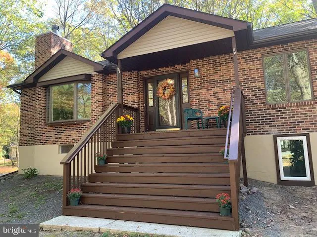 a view of a house with wooden stairs and a table and chairs