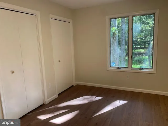 a view of a room with wooden floor and small window