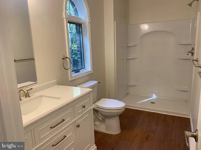 a bathroom with a sink toilet a mirror and shower