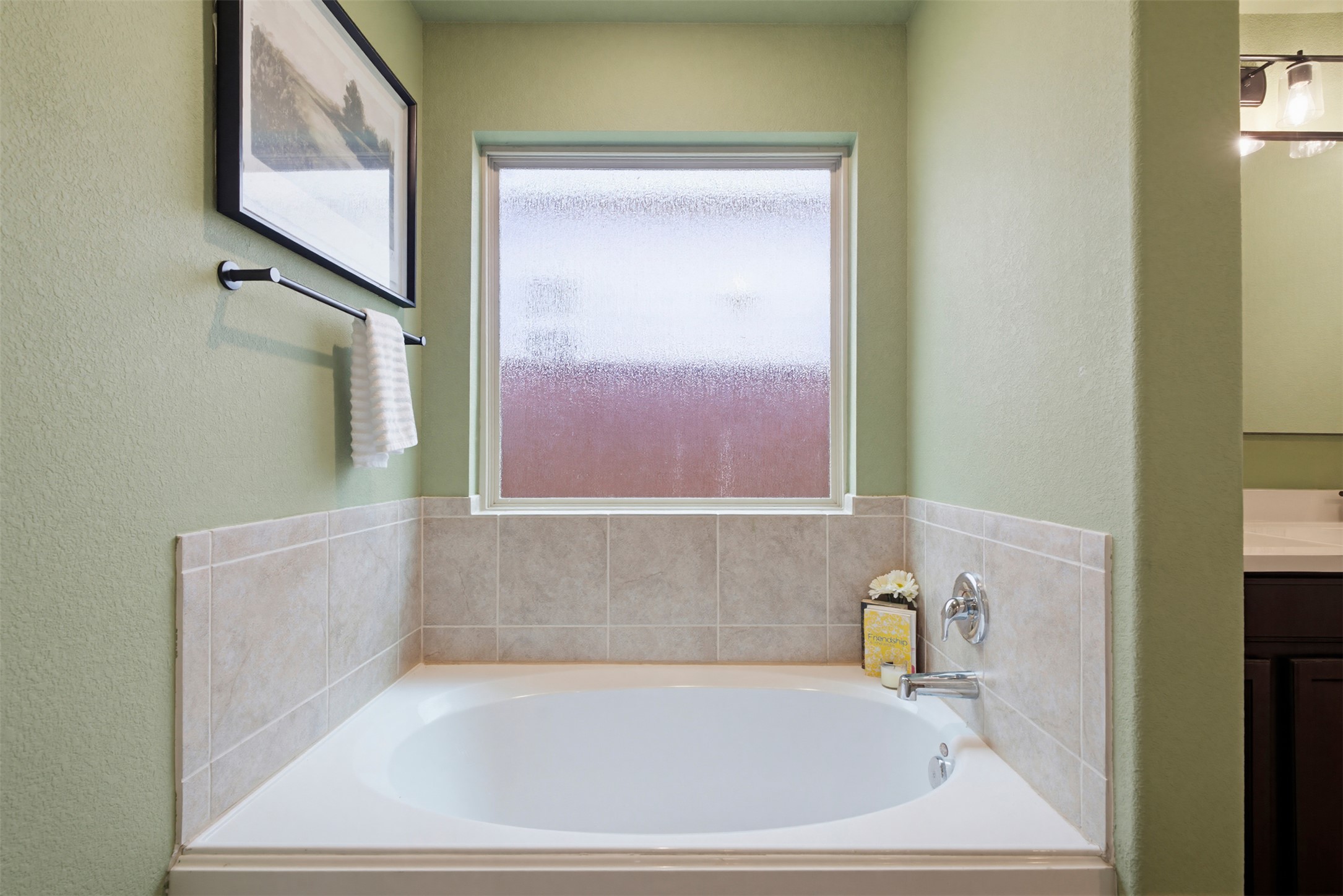 5705 Southerner Way Austin, TX 78747 - Photo 11 of 22 A spacious tub, elegantly framed by soft green walls, awaits tranquil relaxation.