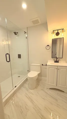 a bathroom with a sink a toilet and shower