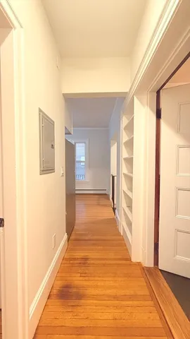 a view of a hallway with wooden floor