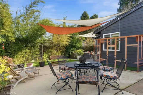 a view of backyard with table and chairs and potted plants