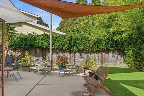 a view of a patio with couches table and chairs and potted plants
