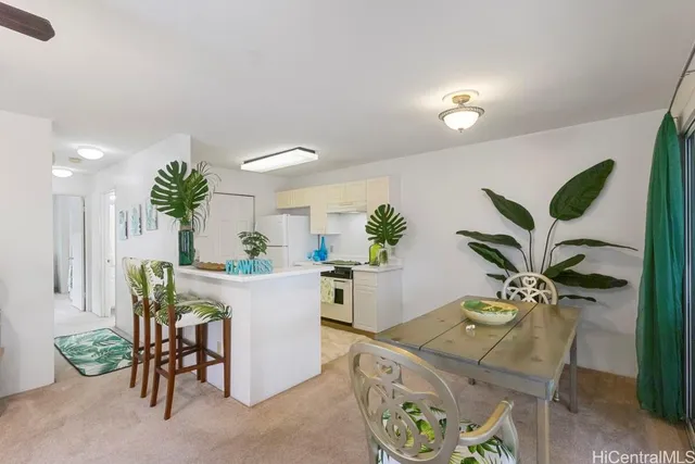 a view of a dining room with furniture and a potted plant