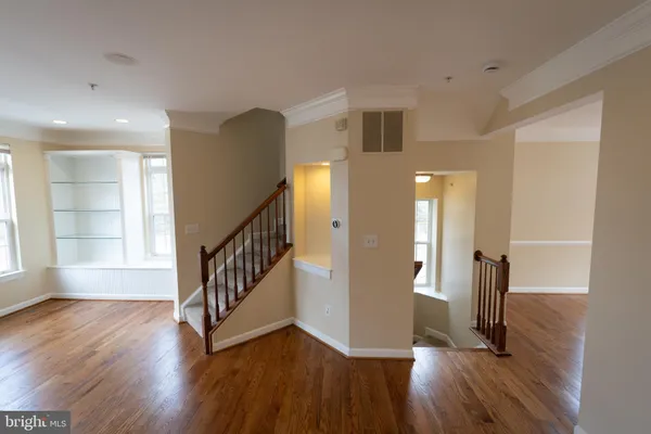 a view of hallway with stairs and wooden floor