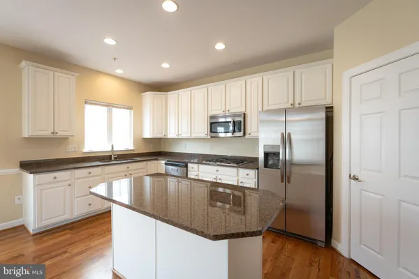 a kitchen with kitchen island a counter top space a sink and refrigerator