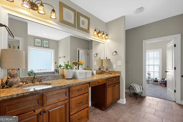 a spacious bathroom with a granite countertop double vanity and a mirror