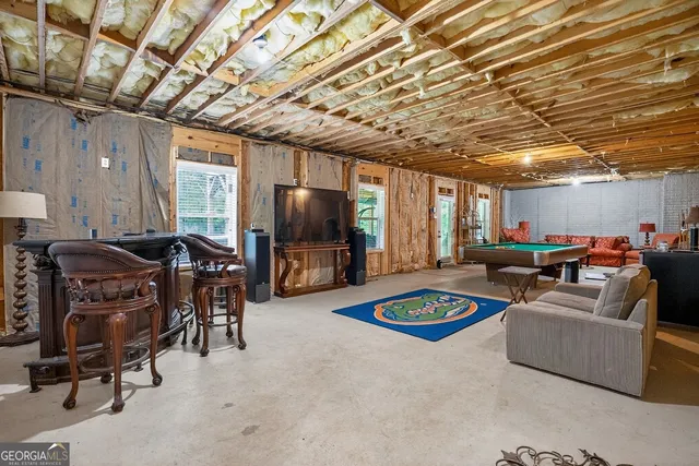 a living room with furniture a flat screen tv and a table