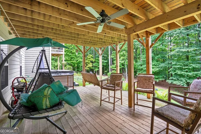 a view of a patio with table and chairs potted plants with wooden floor and fence