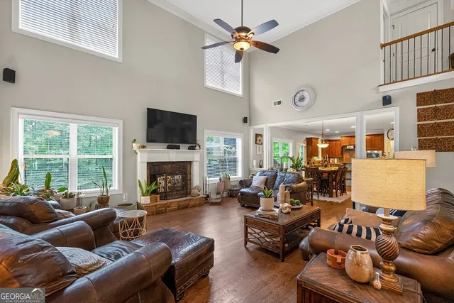a living room with furniture fireplace and a large window