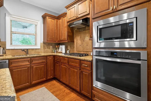 a kitchen with stainless steel appliances a stove a microwave and sink