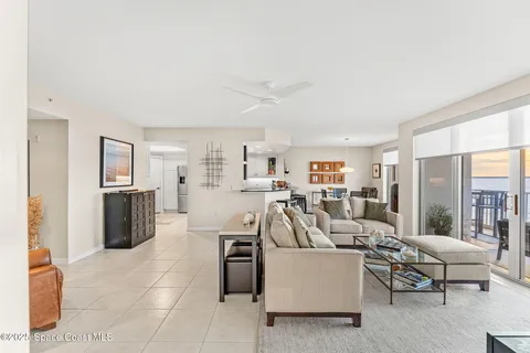 a view of a patio with table and chairs potted plants with floor to ceiling window and potted plants