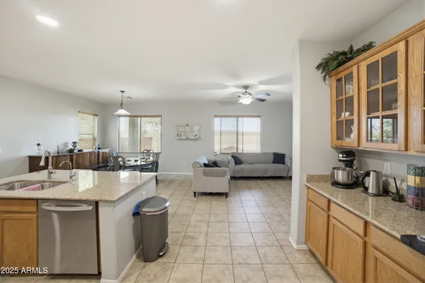 a kitchen with a stove a sink a kitchen island with a dining table and chairs