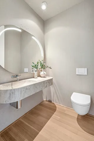 a bathroom with a toilet a sink a mirror and bathtub